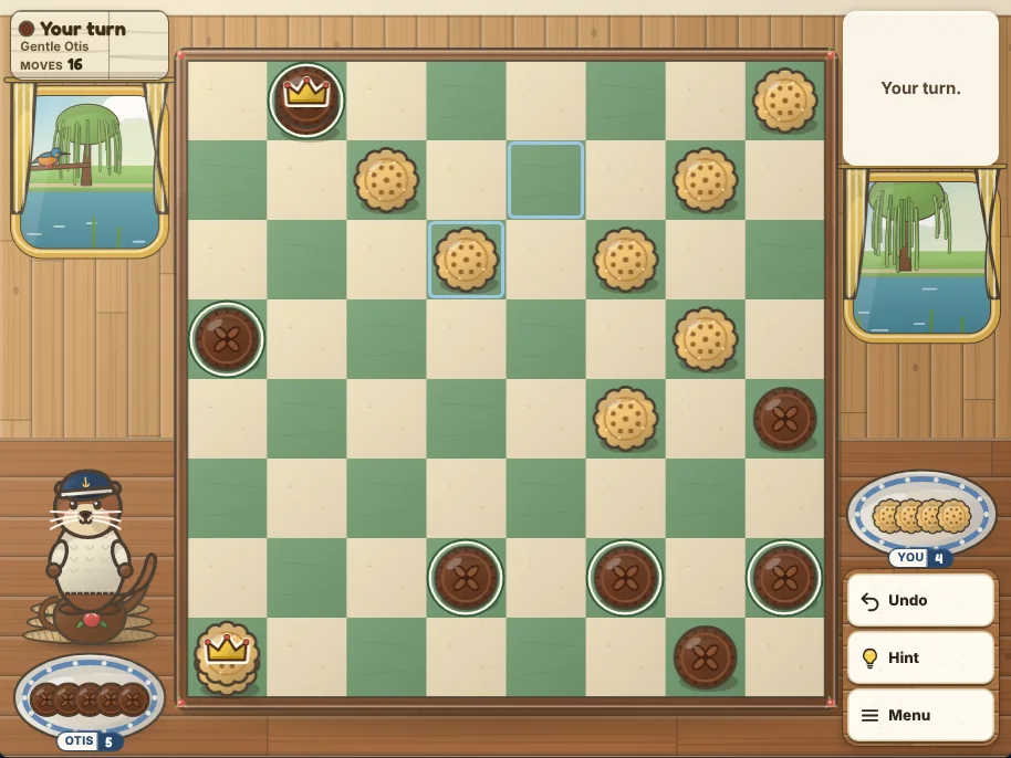 Actual Kingfisher Canal Checkers gameplay on a desktop browser: the cream and sage checkerboard in the middle of a canal boat table, chocolate cookies at the bottom and shortbread cookies at the top with a king of each color crowned in gold icing, the pieces that can move ringed, Otis the otter on his rope coil at the left under the turn sign, the plates of taken pieces beside the board, and Undo, Hint and Menu on the right.