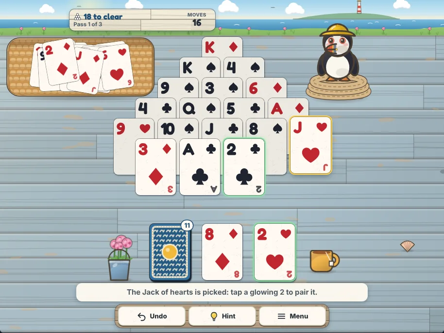 Actual Puffin Bluff Solitaire gameplay in a desktop browser: a three-pass winnable deal after 16 moves with 18 pyramid cards left. The Jack of hearts is picked and lifted, and the 2 of clubs in the pyramid and the 2 of hearts on the waste glow as the cards it can pair with. Removed cards lie in the woven tray, the face-down stock holds 11 cards with the 8 of diamonds turned up beside it, and Skipper the puffin stands on her coil of rope.